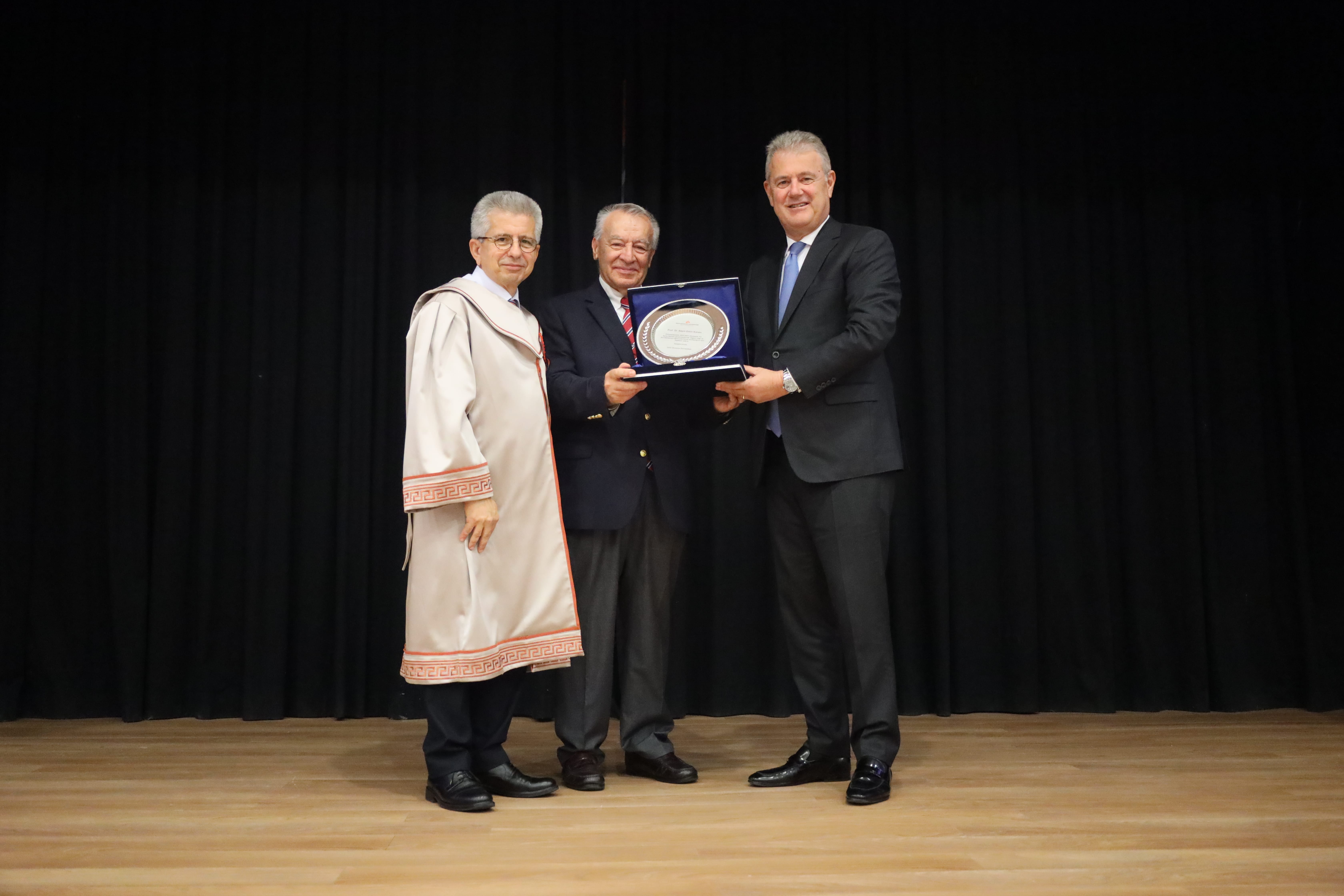 İEÜ Mütevelli Heyet Başkanı Mahmut Özgener ve Rektör Prof. Dr. Yusuf Hakan Abacıoğlu, ilk ders konuşmasını gerçekleştiren Prof. Dr. Emin Kansu'ya plaket takdim etti.